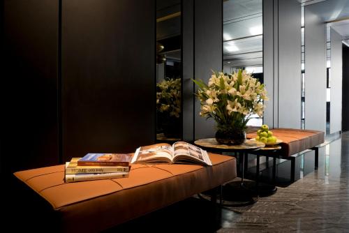 a room with a table with books and a vase of flowers at Venue Hotel The Lily in Singapore