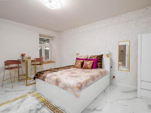 Un dormitorio blanco con una cama grande con almohadas moradas en Apartament Gold Aleja NMP 8 - Free parking en Częstochowa