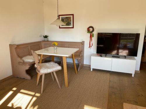 a dining room with a table and a tv at Ferienwohnung Christensen in Murnau am Staffelsee