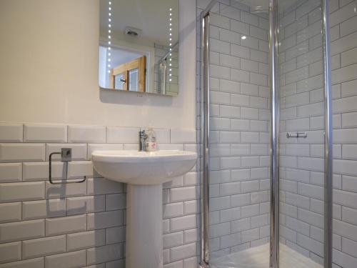 a white bathroom with a sink and a shower at Ayla in Lyme Regis