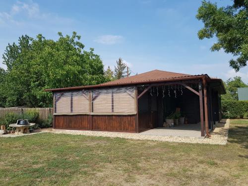 ein Gebäude mit einer Garage im Hof in der Unterkunft ZöldPortál Vendégház Tiszanána -Dinnyéshát 