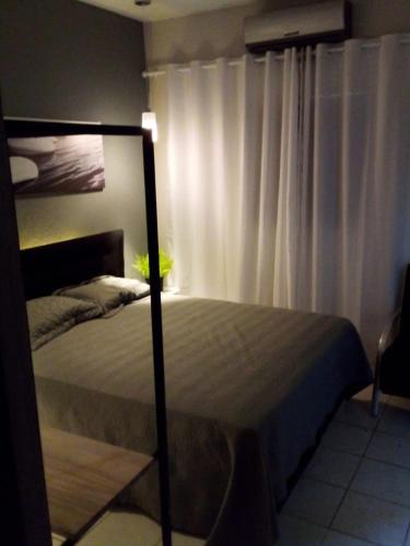 a bedroom with a bed and a white curtain at flat Luiz Carlos Mouzinho in Teresina