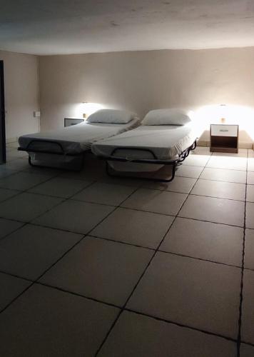 two twin beds in a room with a light at Domenico 's in Ruvo di Puglia