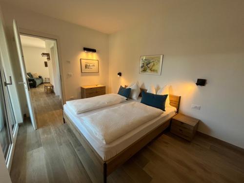 a bedroom with a large white bed with blue pillows at Apartment Ansitz Unterwinkel in Caldaro
