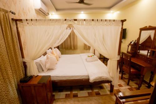 a bedroom with a canopy bed and a piano at Hotel Cecil in Kolkata