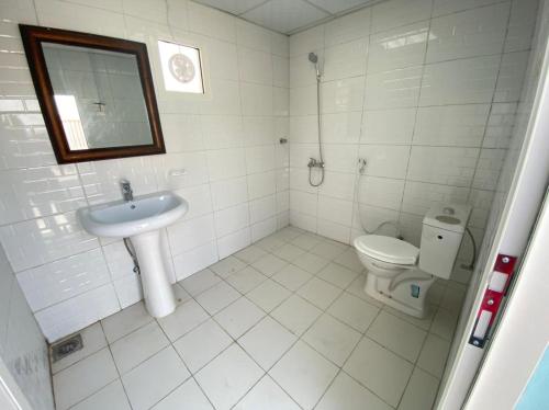 Baño blanco con lavabo y aseo en private farmhouse Tent Room, en Al Rahba
