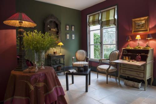 - un salon avec une table et un bureau avec des chaises dans l'établissement Les Buis de Boscherville Gite, à Hénouville