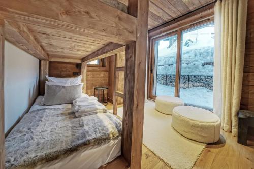 sypialnia z łóżkiem i dużym oknem w obiekcie Chalet Whymper avec piscine 150m téléphérique (neuf 2021) w mieście Megève
