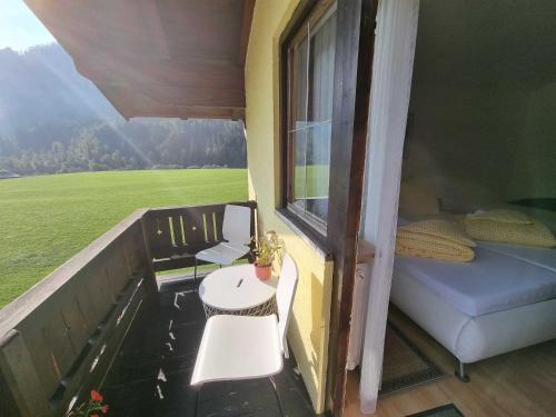 a balcony with a bed and a table and a window at Apia House in Unken