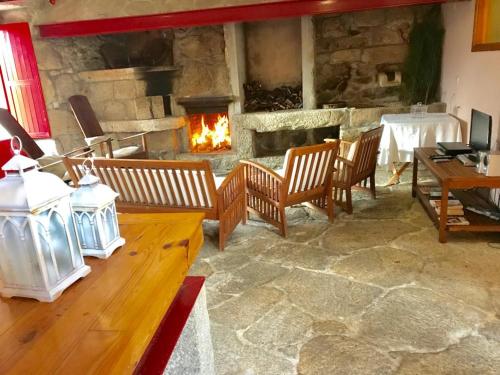 a living room with a fireplace and a table and chairs at Janelas da Cabreira in Campos