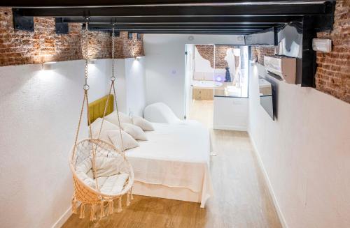 Zimmer mit einem Schaukelbett und einer Küche in der Unterkunft Calle Amparo 86 Lujoso Dúplex con Jacuzzi en Lavapies especial parejas in Madrid