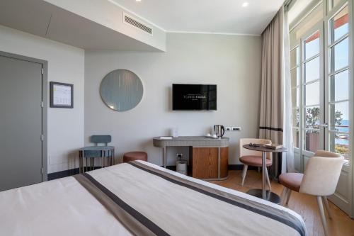 a hotel room with a bed and a desk and a tv at Grand Hotel Torre Fara in Chiavari