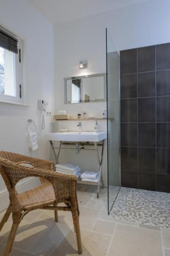 une salle de bain avec un lavabo et une douche en verre dans l'établissement Les Buis de Boscherville Gite, à Hénouville