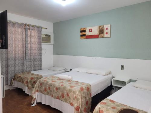 a hotel room with two beds and a window at Hotel Cidade De Bauru in Bauru