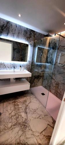 une salle de bain avec un lavabo et une douche dans l'établissement Superbe appartement climatisé proche plages, grande terrasse et parking privé, à Antibes