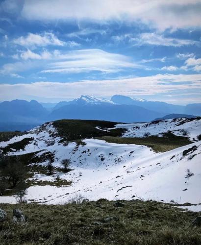 a snow covered hill with mountains in the distance at Hotel Apostoli in Përmet
