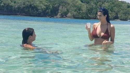 two women in the water with a cup of coffee at VILLA CAPACITE 6 PERSONNES PROCHE PLAGES DU Sud in Rivière-Pilote