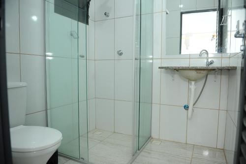 een badkamer met een douche, een toilet en een wastafel bij Pousada Gruta do Anjo in Socorro