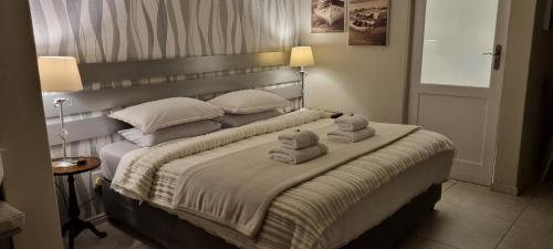 een slaapkamer met een groot bed en handdoeken bij Studio in Hout Bay near the beach in Hout Baai