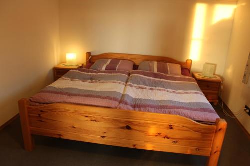 ウールディンゲン・ミュールホーフェンにあるBodenseegästehausのベッドルーム1室(木製ベッド1台、ナイトスタンド2台付)