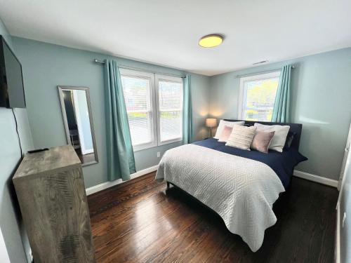 a bedroom with a bed with blue walls and wooden floors at The Absolute Best Home Away From Home Pet Friendly!!! in Wilmington