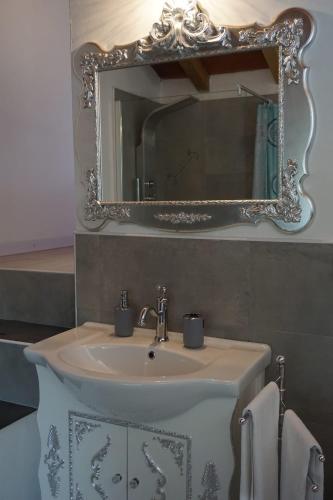 a bathroom with a sink and a mirror at Notte Rosa Suites & Relax in Fornovo di Taro