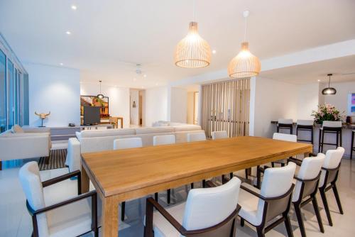 a dining room with a large wooden table and white chairs at Dreams Karibana Cartagena Golf & Spa Resort in Cartagena de Indias