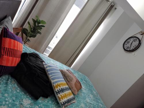 a room with two pillows on a couch with a clock at En el centro y hermosa vista! Con cochera in Trujillo