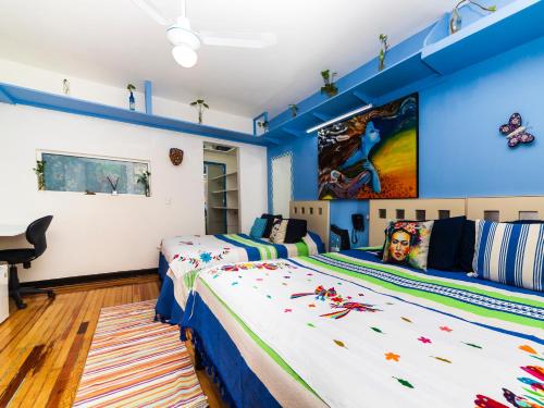 2 camas en una habitación con paredes azules en Casa ITZAE B&B- Lincoln Park dog friendly, en Ciudad de México