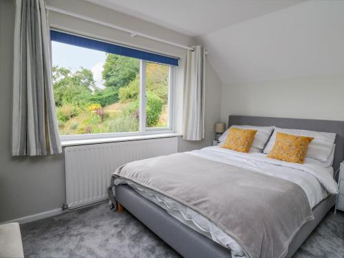 a bedroom with a bed and a large window at Lleifior in Dolgellau