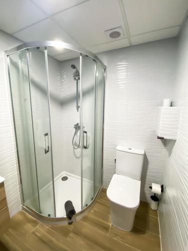 a bathroom with a glass shower and a toilet at Apartamentos Pueblo Mar in Calpe