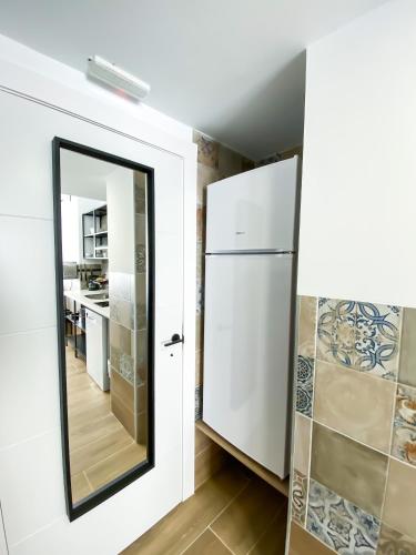 a mirror in a kitchen next to a refrigerator at Apartamentos Pueblo Mar in Calpe