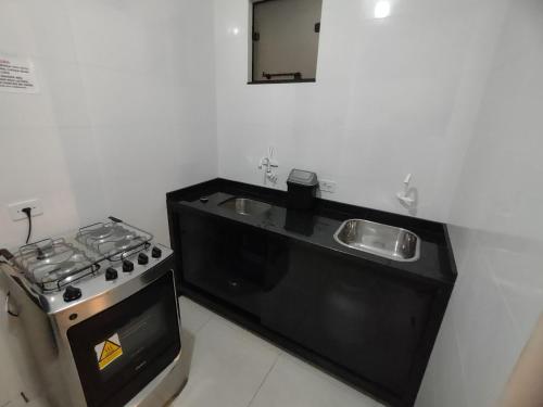 Il comprend une cuisine équipée d'une cuisinière et d'un évier. dans l'établissement Condominio Boa Vista, à Pontal do Paraná