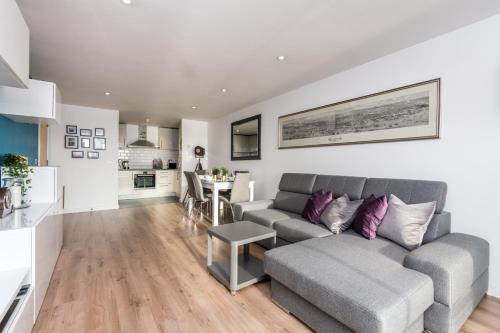 ein Wohnzimmer mit einem Sofa und einem Tisch in der Unterkunft Host & Stay - The Baltic Penthouse with Balcony in Liverpool