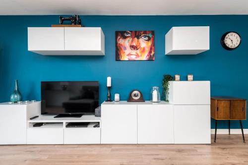ein Wohnzimmer mit weißen Schränken und einer blauen Wand in der Unterkunft Host & Stay - The Baltic Penthouse with Balcony in Liverpool