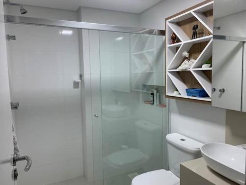 a bathroom with a shower and a toilet and a sink at Apartamento Beira Mar in Arroio do Silva