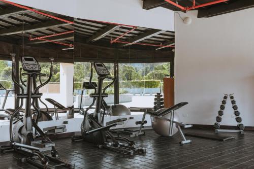 a gym with treadmills and exercise bikes in a room at Travelers Rio Verde Living Suites in Rionegro