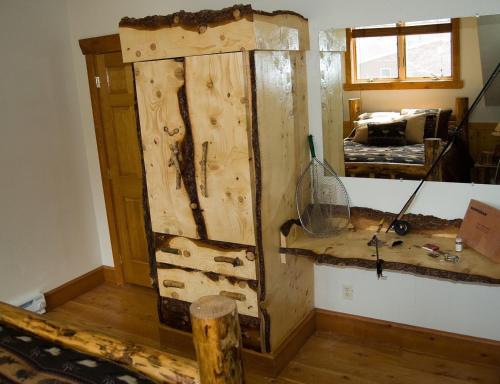 a wooden cabinet in a room with a bedroom at River's Bend Lodge in Cascade