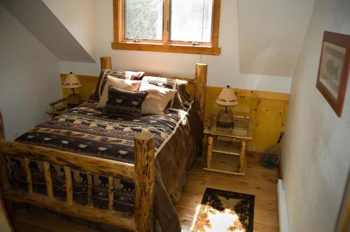 a bedroom with a wooden bed and a window at River's Bend Lodge in Cascade