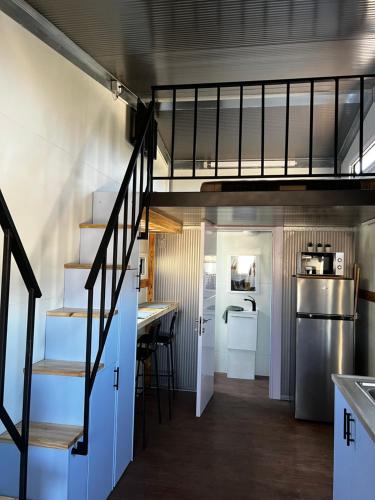 a kitchen with a stairs leading up to a loft at צימראוון בחוות זית המדבר in Sede Boqer