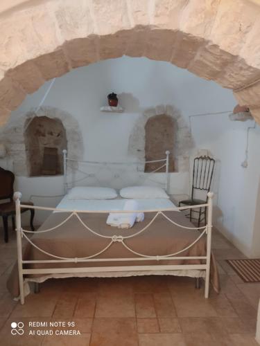 1 dormitorio con 1 cama en una habitación de piedra en Masseria Calò, en Monopoli