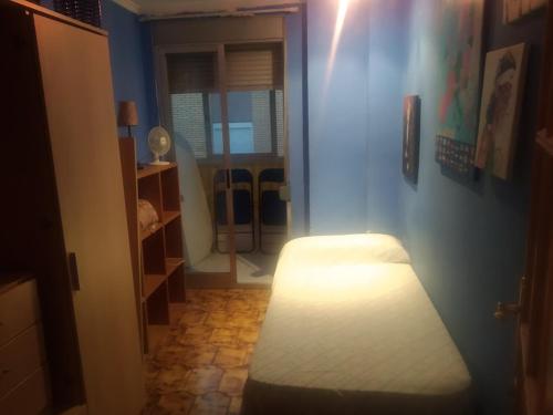 Zimmer mit einem Bett in einem blauen Zimmer in der Unterkunft Piso entero cerca de Valencia y sus playas. in Albalat dels Sorells