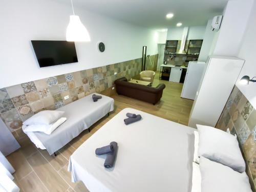 a hotel room with two beds and a living room at Apartamentos Pueblo Mar in Calpe