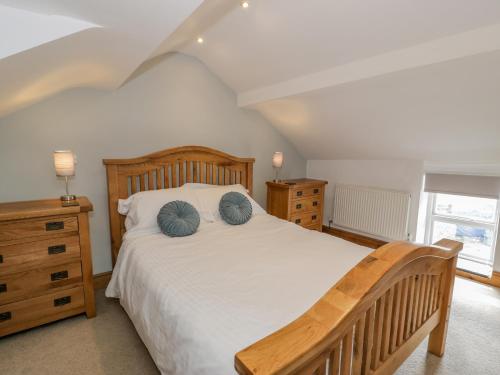 a bedroom with a wooden bed with blue pillows at Pen Y Bont Ucha in Llandudno Junction