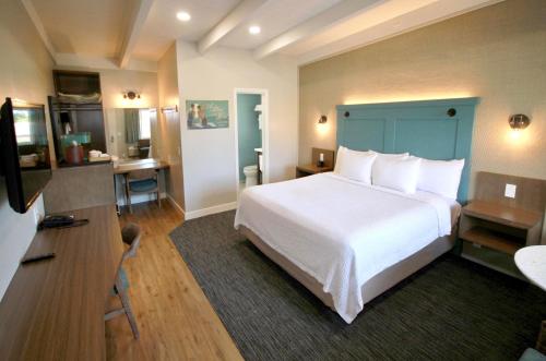 a bedroom with a large white bed and a desk at Castle Inn in Cambria
