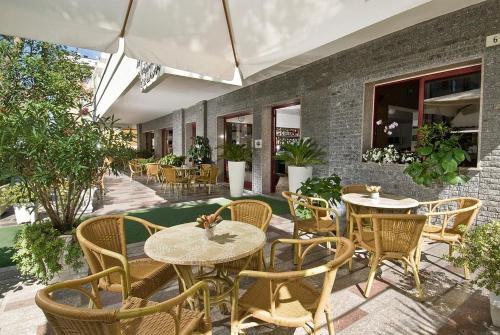 un'area salotto all'aperto con tavoli e sedie di Hotel Capinera a Rimini