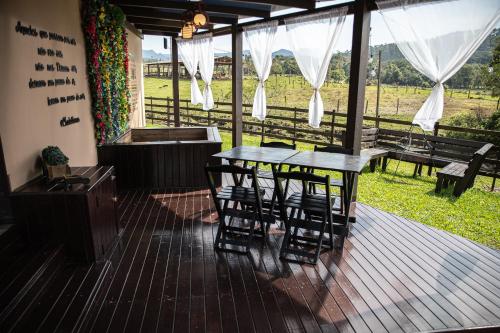 a patio with a table and chairs on a deck at @Chalet.Home in Nova Veneza