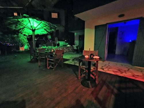 a patio with tables and an umbrella at night at IRIS STUDIOS in Agios Nikitas
