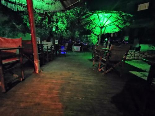 ein Esszimmer mit Tischen und einem Sonnenschirm in der Nacht in der Unterkunft IRIS STUDIOS in Agios Nikitas