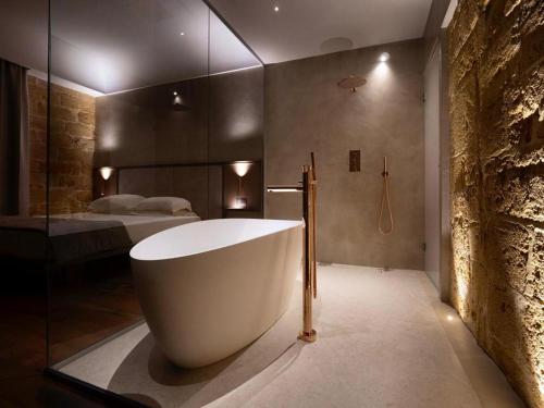a bathroom with a bath tub and a bedroom at Villa Favorita Hotel & Events in Marsala